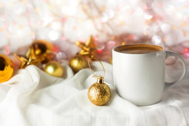 Christmas coffee mug mockup golden decoration bokeh lights background White cup with hot drink design demonstration templateWinter New Year holiday greeting card cozy home festive concept Copy space