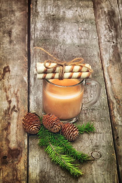 Christmas coffee with milk branch of fir with cones old retro vintage wood background