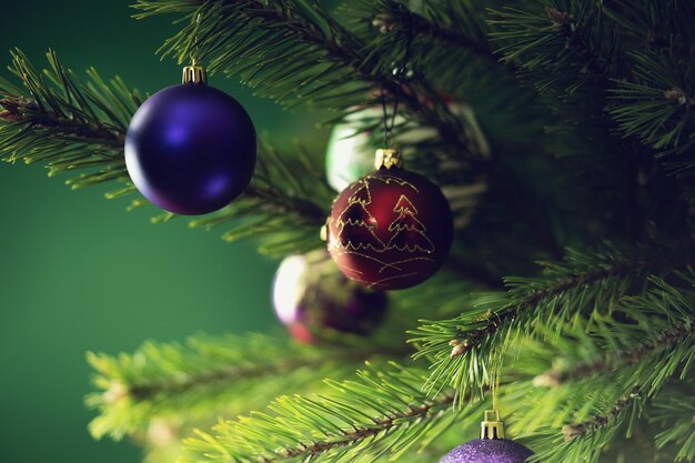 Foto composizione natalizia palle su un albero di natale in primo piano su uno sfondo verde