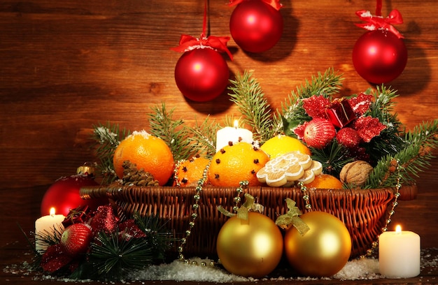 Composizione natalizia in cesto con arance e abete, su fondo in legno