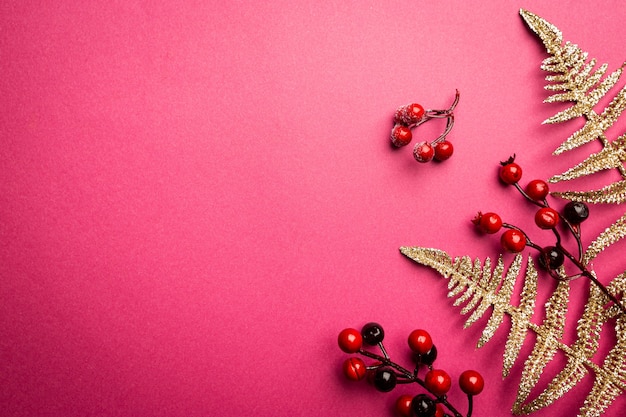 Christmas composition branches of red berries on pink background christmas winter new year concept