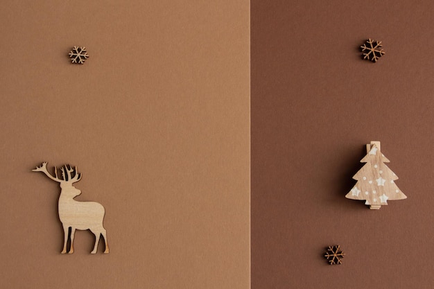 Christmas composition on a brown background wooden deer snowflakes copy space