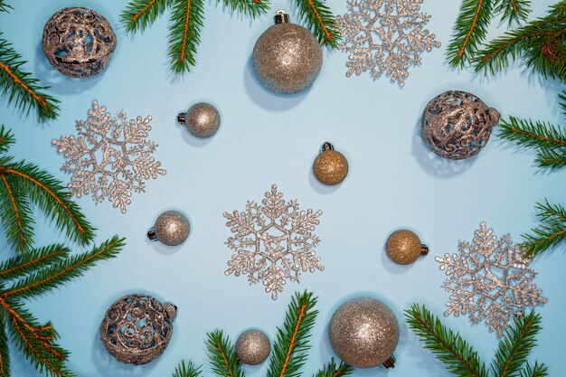 Christmas composition. Christmas balls, Christmas tree and silver snowflakes on a blue background.