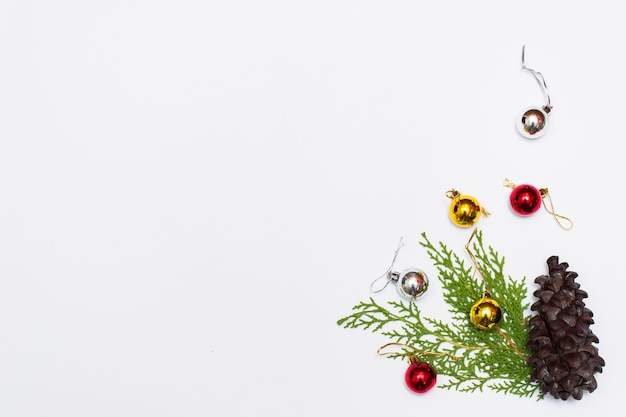 Рождественская композиция. Рождественский подарок, конусы, еловые ветки на белом фоне. Плоский, вид сверху
