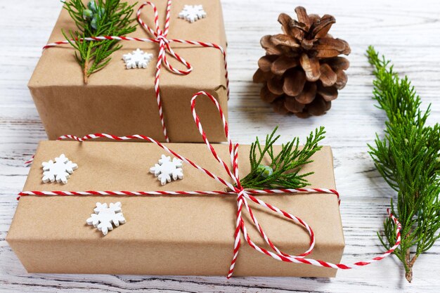 Photo christmas composition christmas gift knitted blanket pine cones fir branches on wooden white background flat lay top view