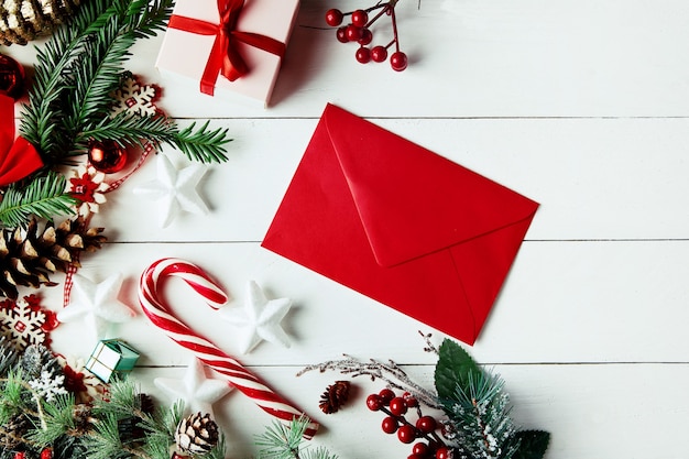 Christmas composition. Christmas gift, pine cones, fir branches on wooden white background.