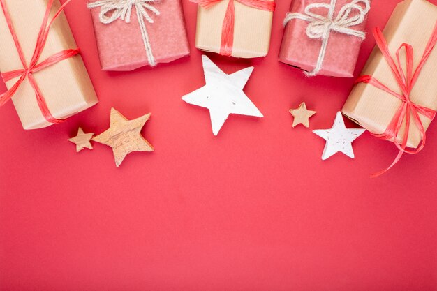 크리스마스 구성. 빨간색 배경에 크리스마스 빨간 장식, 별 및 선물 상자. 평평한 누워, 평면도, 텍스트를위한 공간