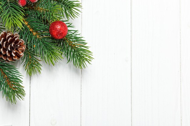 Рождественская композиция Ветка елки с игрушками-шишками на деревянном фоне