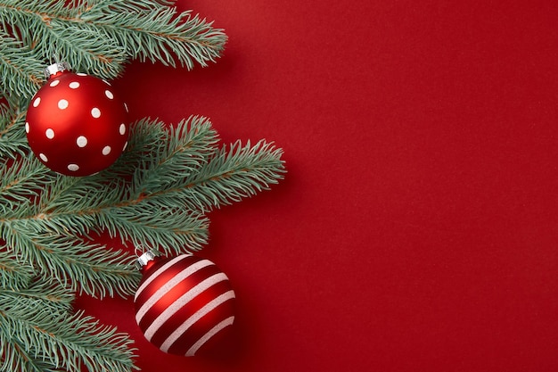 クリスマスの構成クリスマスツリーの枝と赤い背景の装飾品