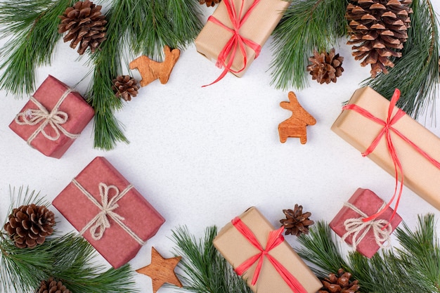 Christmas composition. Christmas white decorations, fir tree branches with toys gift boxes on white background. Flat lay, top view, copy space, greeting card