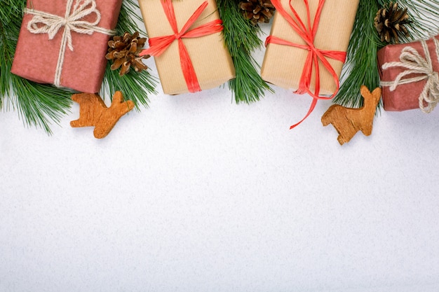 クリスマスの組成物。白いクリスマスの装飾、白い背景の上のおもちゃギフトボックスとモミの木の枝。