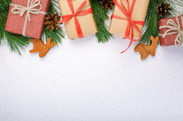 Christmas composition. Christmas white decorations, fir tree branches with toys gift boxes on white background.