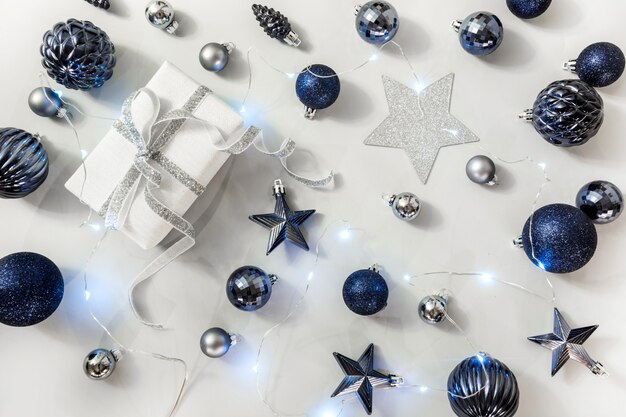 Christmas composition of classic blue balls and giftbox on grey