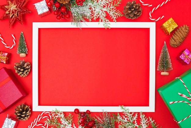 赤い背景の上の写真の正方形のフレームとクリスマスの構成の装飾モミの木の枝