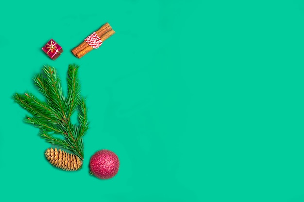 Christmas composition of fir branches, cone, cinnamon and decoration on a green for postcards, covers. new year concept. Top view, flat lay, copy space for text