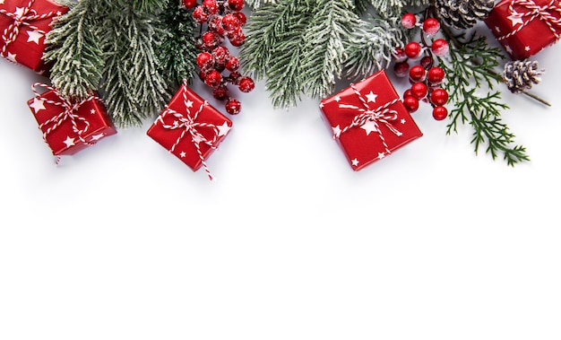 Christmas composition. Fir tree branches, red decorations on white