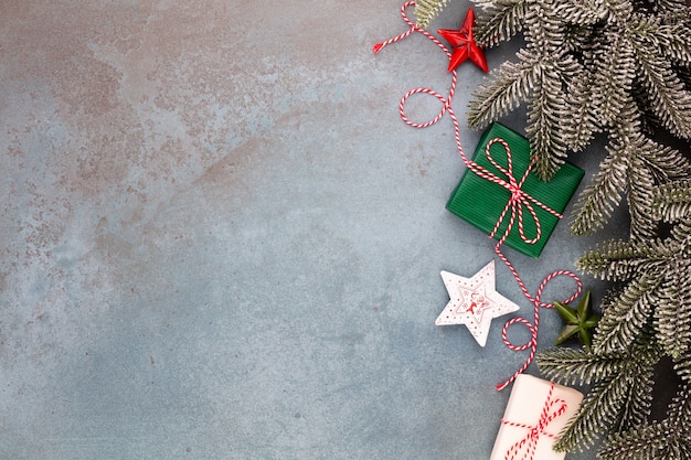 Christmas composition fir tree branches, star ornaments on blue background.