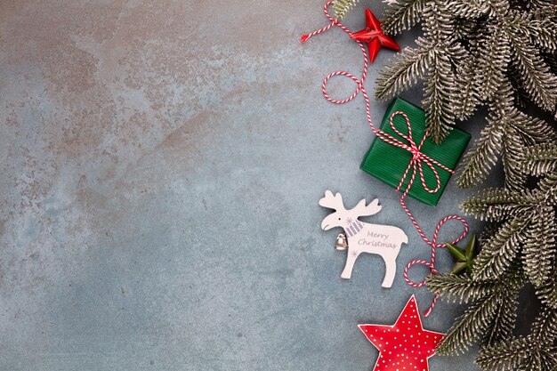 Christmas composition fir tree branches, star ornaments on blue background.