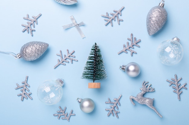 Foto composizione in natale abete e decorazione d'argento su sfondo blu pastello. natale, inverno, concetto di capodanno. disposizione piatta, vista dall'alto, spazio di copia - immagine