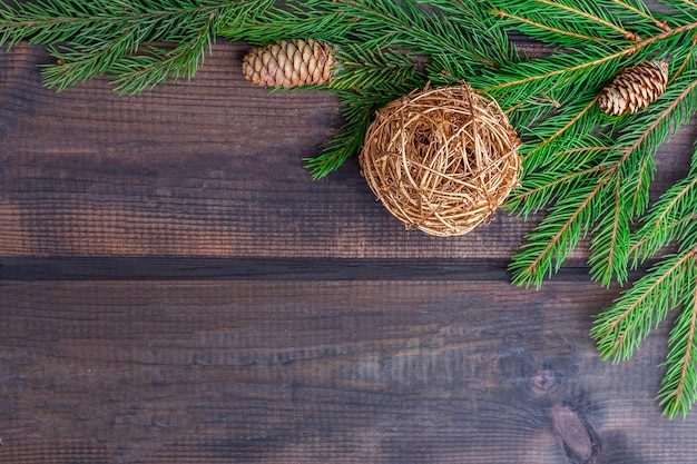 Christmas composition. Frame of the fir branches and balls on a dark rustic wood