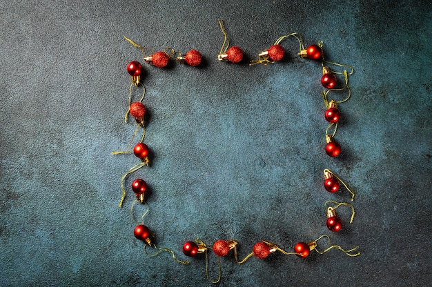 Christmas composition. Frame made of christmas decor and toys on dark background. Top view, copy space. Christmas flat lay. New Year backgroud. New year 2022. New Year concept