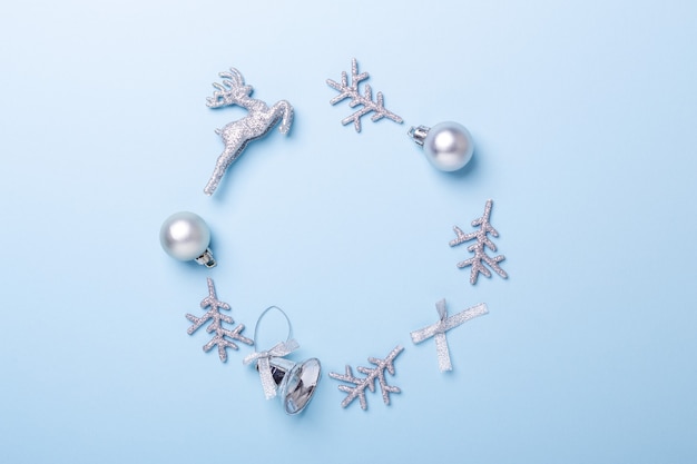 Photo christmas composition. frame made of silver decoration on pastel blue background. christmas, winter, new year concept. flat lay, top view, copy space - image