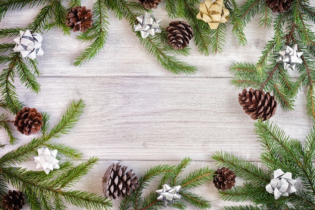 Christmas composition, frame. Spruce branches decorated with gold and silver bows and cones, laid out in a circle. In the center of Copy Space.