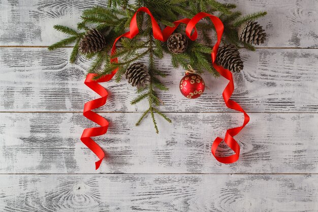 Christmas composition. Frame with fir branches, pine cones, christmas balls, ribbon and tinsel. Flat lay, top view