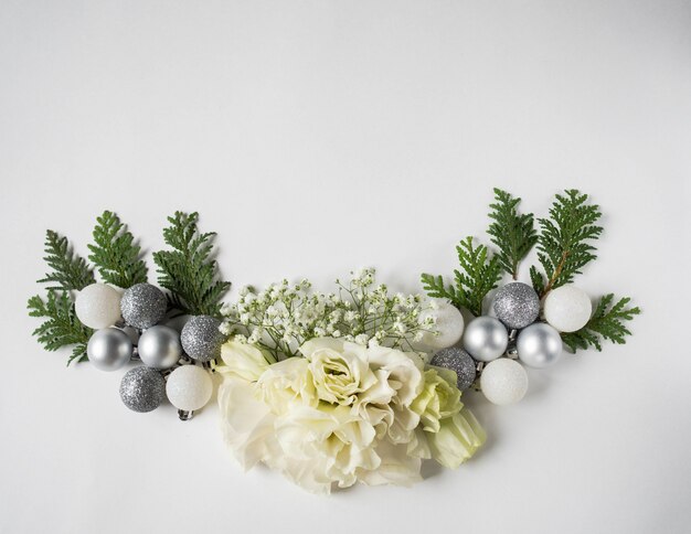 Christmas composition of fresh white flowers, silver Christmas balls and thuja