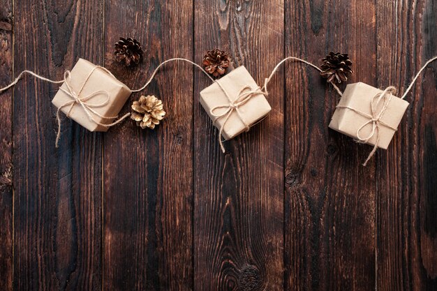 Christmas composition from gift boxes and cones on a wooden background