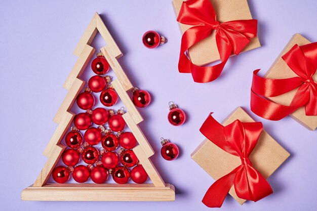 Christmas composition of gift boxes and Wooden christmas tree with red christmas balls inside