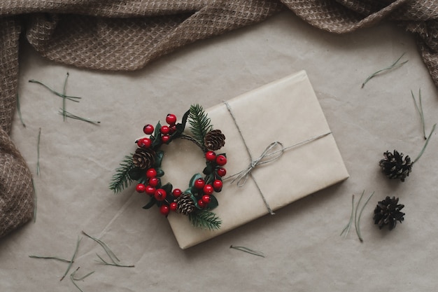 Christmas composition. Gift, fir tree branches, balls on craft paper background. Christmas, winter, new year concept. Flat lay, top view, copy space.