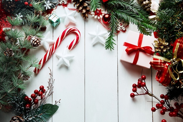 Новогодняя композиция. Подарки, еловые ветки, красные украшения на белом фоне. Рождество, зима, новогодняя концепция.
