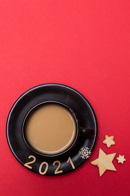 Christmas composition numbers 2021 and a cup of coffee on a red