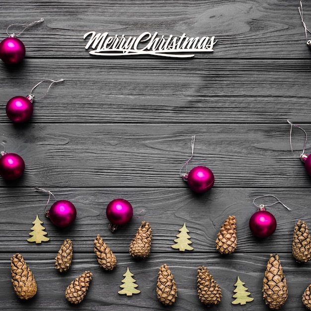 Christmas composition of pine cones, wooden green tree and small pink balls