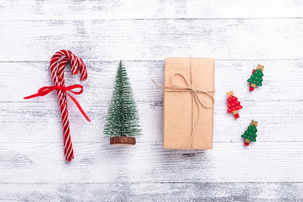 Foto composizione di natale. casella attuale, regali, abete, bastoncini di zucchero su fondo di legno. disposizione piatta, vista dall'alto - immagine