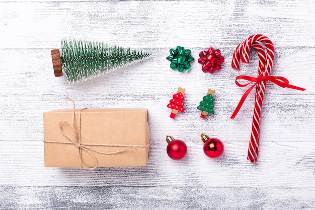 Christmas composition. Present box, gifts, fir tree, candy canes on wooden background. Flat lay, top view - Image