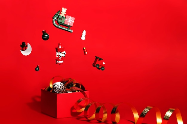 Christmas composition of red color with shining toys flying in the air.