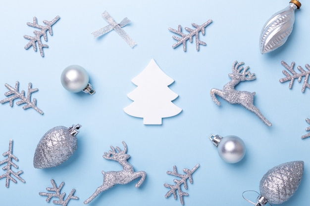 Photo christmas composition. silver decoration on pastel blue background. christmas, winter, new year concept. flat lay, top view, copy space - image