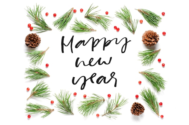 Christmas composition on a white background. Pine branches and cones. Happy New year-handwritten inscription.