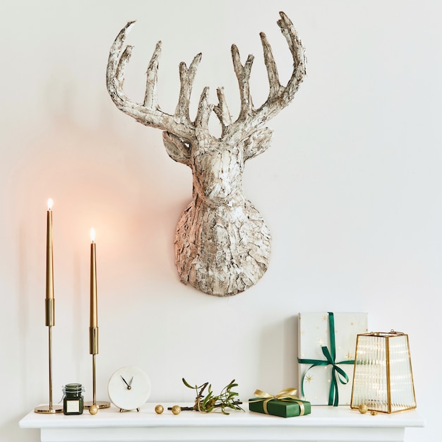 美しい装飾が施されたリビングルームのインテリアの白い煙突のクリスマスの構成。クリスマスツリーと花輪、キャンドル、星、光。スペースをコピーします。レンプレート。