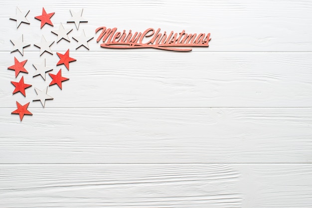 Photo christmas composition on the white wooden background with red wooden label, white and red stars