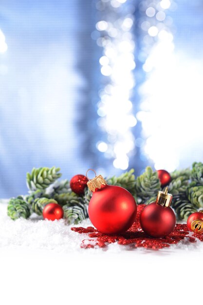 Christmas composition with baubles and fir-tree on snow close-up