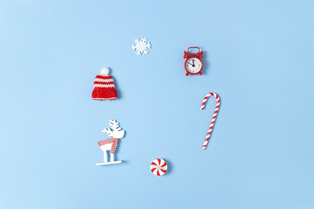 Christmas composition with candy cane, deer, hat, snowflake and red clock