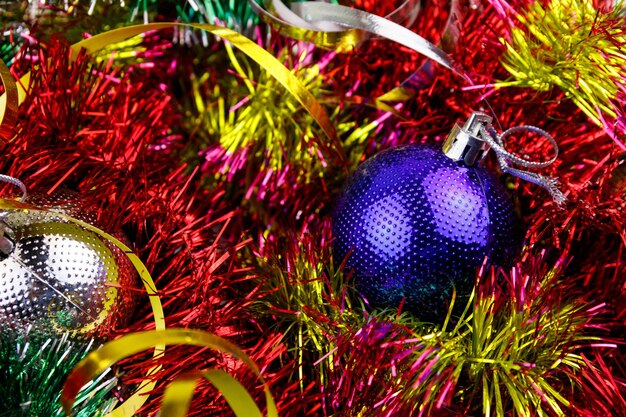 Christmas composition with Christmas baubles and multicolored tinsel Christmas balls in bright tinsel closeup