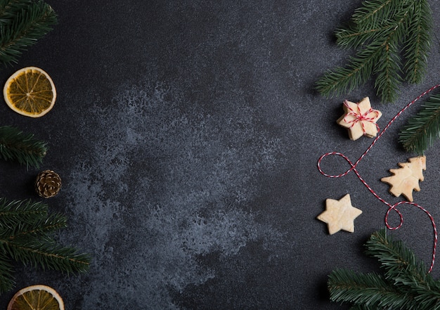 Composizione di natale con biscotti, rami di albero di natale e arance secche.