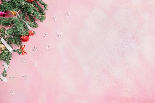 Новогодняя композиция с украшениями и подарочной коробкой с бантами на розовом пастельном фоне. зима, новый год концепция. Плоская планировка, вид сверху, копия пространства.