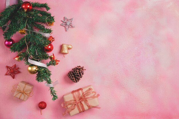 Christmas composition with decorations and gift box with bows on pink pastel background. winter, new year concept. Flat lay, top view, copy space.