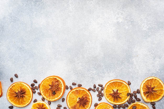 Christmas composition with dried oranges, cinnamon, anise and nuts on a gray concrete background.