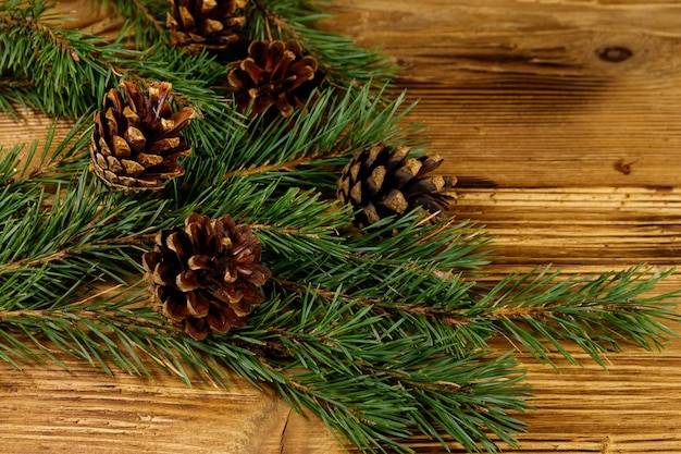 Christmas composition with fir tree branches and cones on wooden background